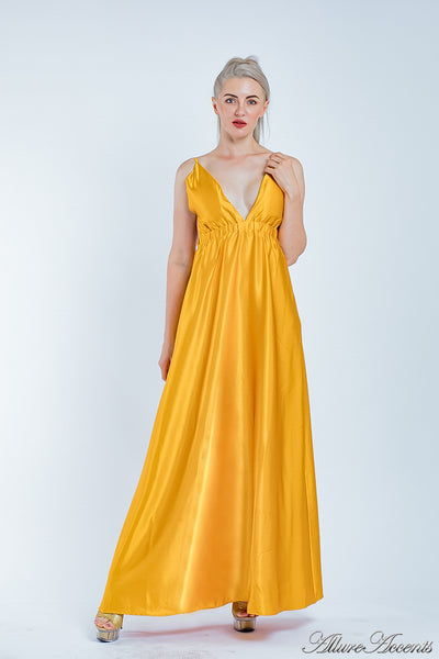 Woman wearing a gold long satin dress that has a deep v neckline.