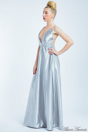 Woman wearing a silver long satin dress that has a deep v neckline.