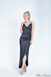 Woman wearing a long black colored silk dress with ruching.