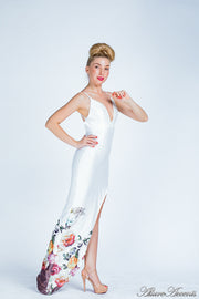 Woman wearing a white summer satin floral party maxi, low cut back and has sexy side slit 