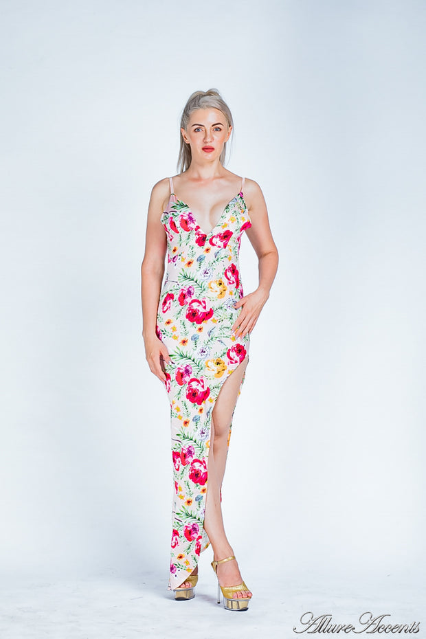 Woman wearing a blush summer satin floral party maxi, low cut back and has sexy side slit 