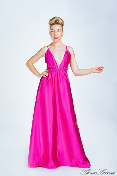 Woman wearing a barbie pink long satin dress that has a deep v neckline.