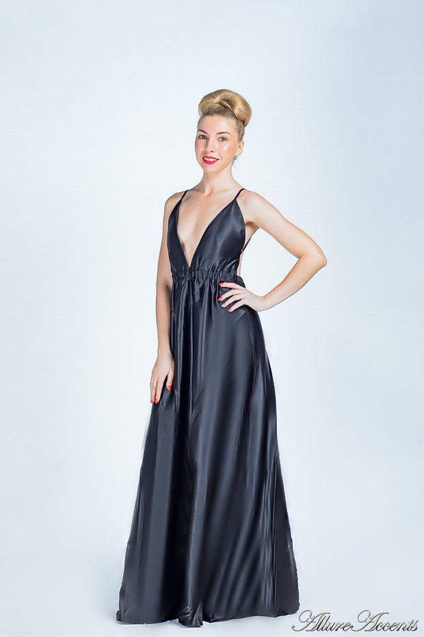 Woman wearing a black long satin dress that has a deep v neckline.