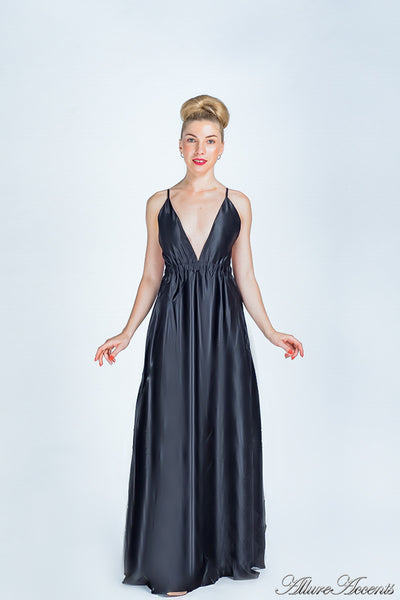Woman wearing a black long satin dress that has a deep v neckline.