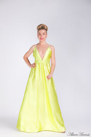 Woman wearing a lemon colored long satin dress that has a deep v neckline.