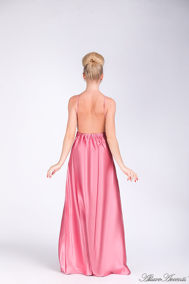 Woman wearing a pink long satin dress showing it has a low back.