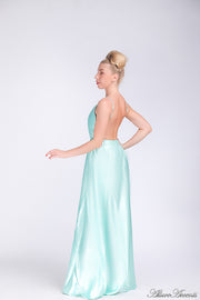 Woman wearing a tiffany blue colored long satin dress that has a deep v neckline.