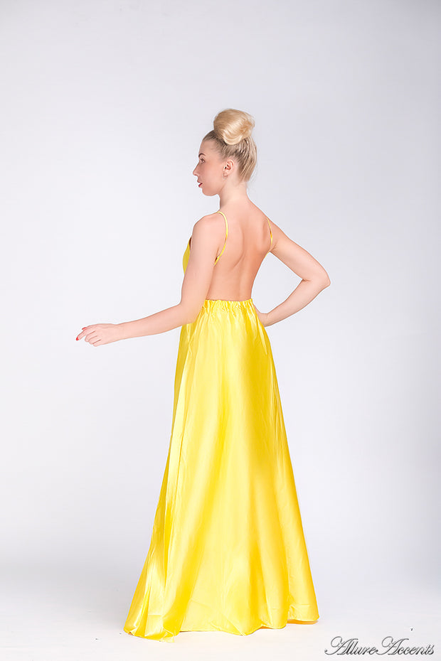 Woman wearing a yellow long satin dress that has a deep v neckline.