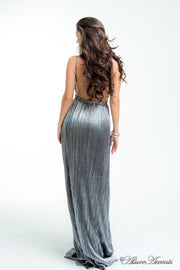 Woman wearing a silver long maxi length slip dress showing it has a low back cut.