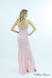Woman showing a baby pink high-low floral lace dress has a low back opening.