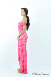 Woman wearing a hot pink off-the-shoulder lace dress with a front slit.