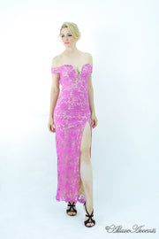 Woman wearing a purple off-the-shoulder lace dress with a front slit. 