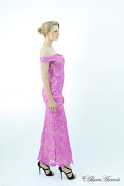 Woman wearing a purple off-the-shoulder lace dress with a front slit.