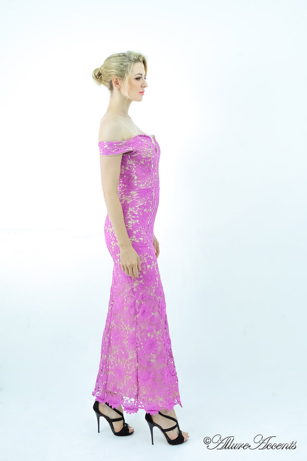 Woman wearing a purple off-the-shoulder lace dress with a front slit.