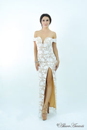 Woman wearing a white off-the-shoulder lace dress with a front slit. 