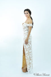 Woman wearing a white off-the-shoulder lace dress with a front slit.
