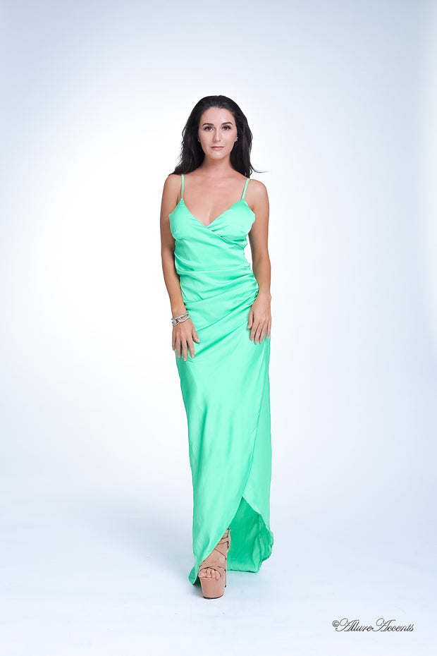 Woman wearing a long lime green colored silk dress with ruching.