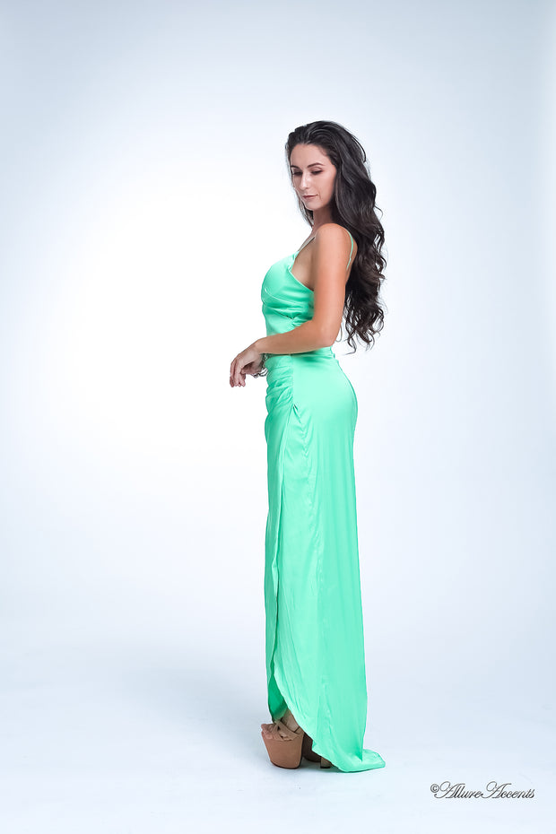 Woman wearing a long lime green colored silk dress with ruching.