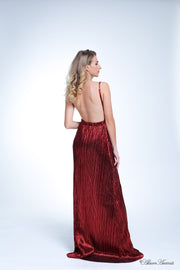 Woman wearing a red colored maxi length slip dress with a deep v neck.