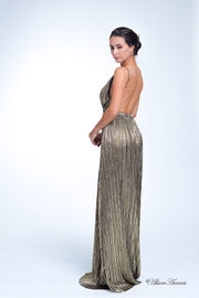 Woman wearing a gold colored maxi length slip dress with a deep v neck.