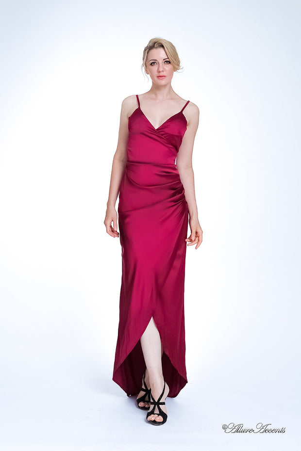 Woman wearing a long wine red colored silk dress with ruching.