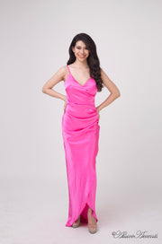 Woman wearing a barbie pink colored silk dress with ruching. 